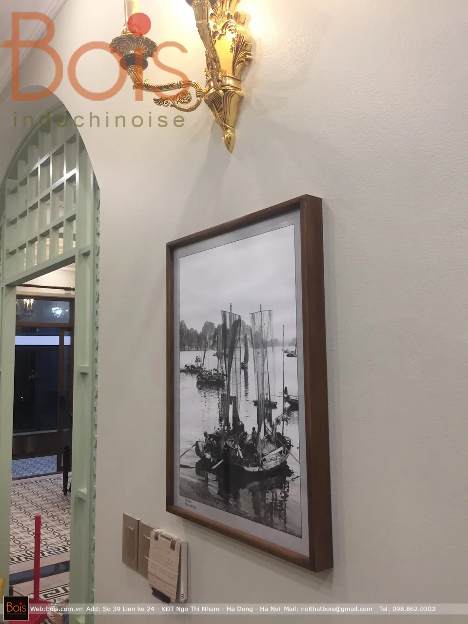 Ảnh tại bàn giao — Một góc nội thất với hình ảnh đen trắng và khung cửa có họa tiết tại thời điểm bàn giao.