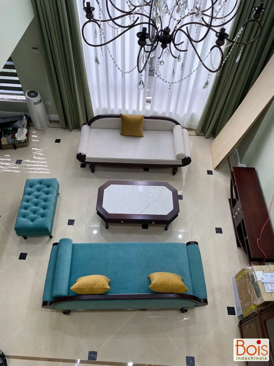 Ảnh thực tế — Nhìn từ hành lang phía trên xuống nhóm ghế và bàn trong khoảng thông tầng.