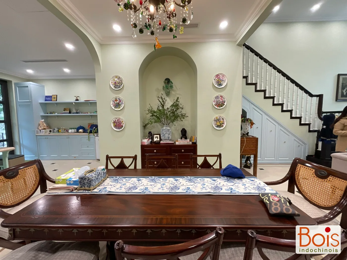 Ảnh thực tế — Tủ bếp màu sáng đi cùng nền tường; màu gỗ trầm tập trung ở nhóm bàn, ghế.